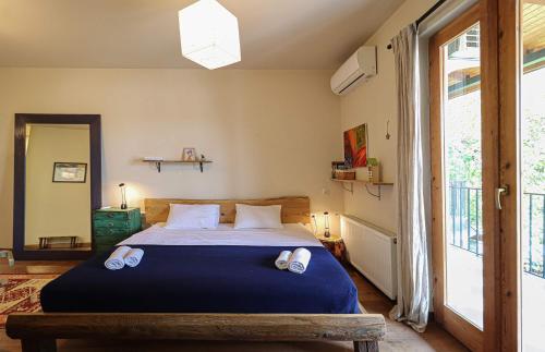 Un dormitorio con una cama con sábanas azules y una ventana. en Luxury Tbilisi House with Garden - by Wehost, en Tiflis