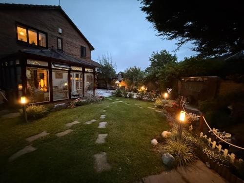 a yard with lights in front of a house at Ceylon HomeStay in Knightswood
