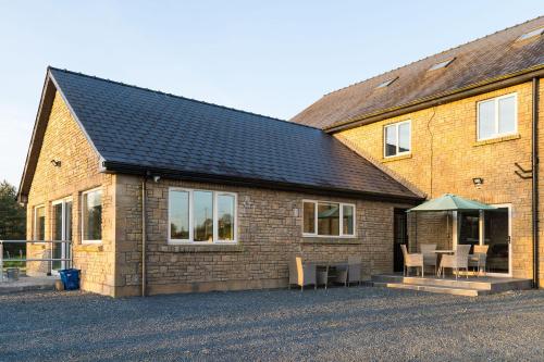 a brick house with a table and chairs outside at Willow Valley in Monaghan