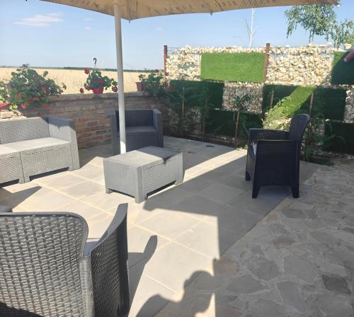 a patio with chairs and a table and an umbrella at ARCADIA Village in Merei