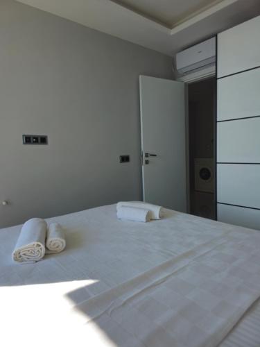 a white bedroom with two towels on a bed at Asiyan Villas in Marmaris