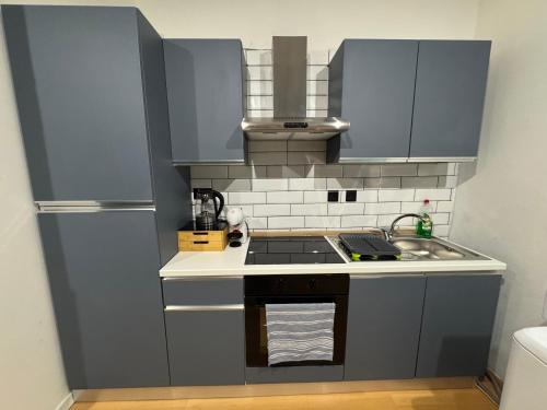 a kitchen with blue cabinets and a sink and a refrigerator at Bentley Floriana Suites in Il-Furjana