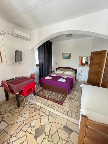 a bedroom with a bed and a table and a couch at Vila Tesmija in Baška