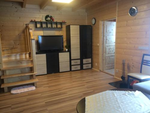 ein Wohnzimmer mit einem Flachbild-TV und einer Treppe in der Unterkunft Domek z widokiem na góry in Targoszów