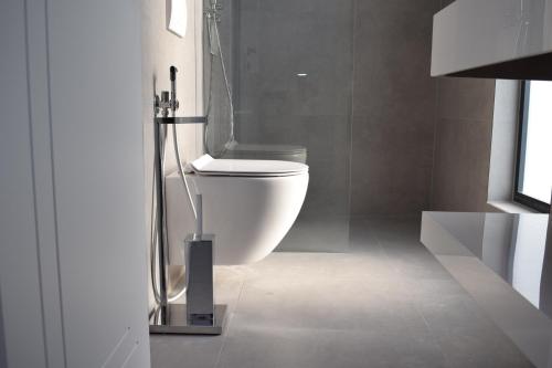 a bathroom with a white toilet in a room at Hotel Sisana in Vlorë