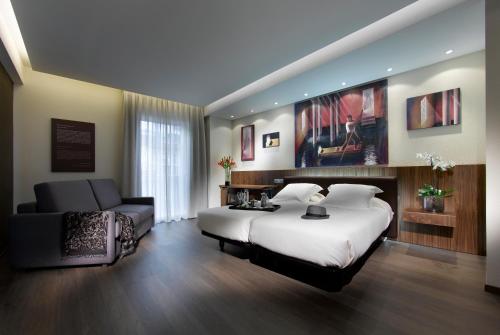 um quarto com uma cama grande e um sofá em BIBO Hotel Recogidas em Granada