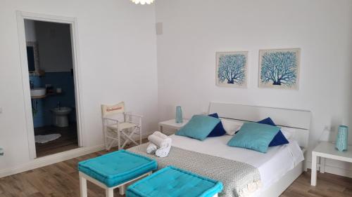 a bedroom with a bed and two blue stools at Casa Isabel in Mazara del Vallo