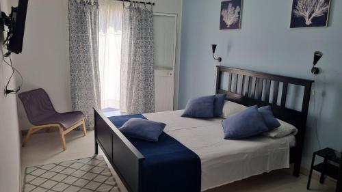 a bedroom with a bed with blue pillows and a window at Casa Isabel in Mazara del Vallo