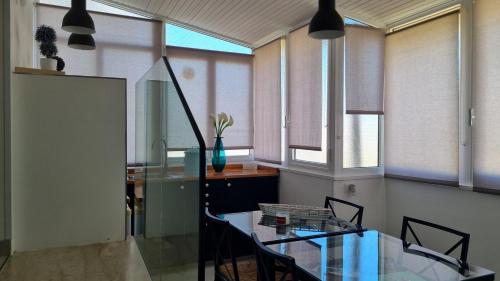 a dining room with a glass table and some windows at Casa Isabel in Mazara del Vallo