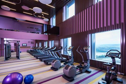 a gym with a row of treadmills and ellipticals at Aloft Taipei Beitou in Taipei