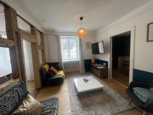 a living room with a couch and a coffee table at Appartement atypique à la Cour-aux-Moines - plein centre historique in Porrentruy