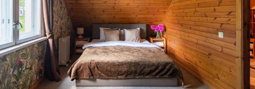 a bedroom with a bed in a log cabin at Slėnis Trakuose in Trakai
