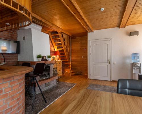 a living room with a kitchen and a brick wall at Slėnis Trakuose in Trakai