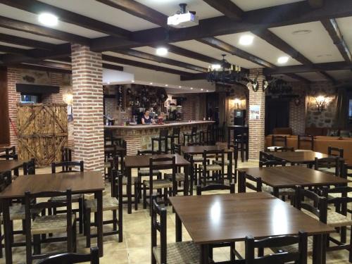 a restaurant with wooden tables and chairs and a bar at Hotel Rural La Cabrera in Robledo del Buey