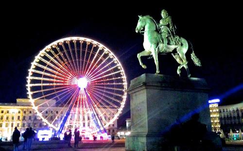 a ferris wheel and a statue of a man riding a horse at Hotel Le Saint Vincent Lyon Sud in Vourles