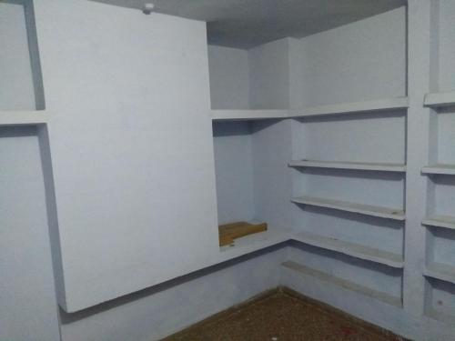 a walk in closet with white walls and shelves at Cozy Homestay in Prayagraj