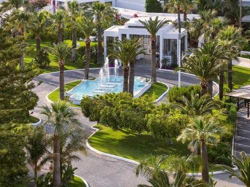 an aerial view of a resort with a fountain and palm trees at Grecotel Creta Palace in Rethymno Town
