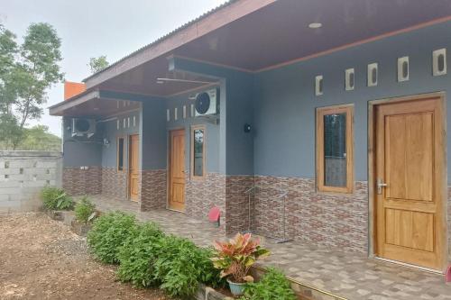 a house with a blue facade with a wooden door at OYO 94714 Khayla Homestay Syariah in Yogyakarta