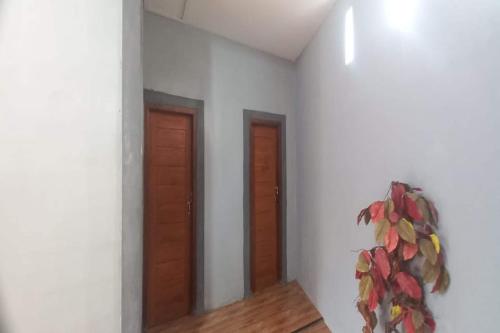 a room with two doors and a plant on the wall at OYO 94714 Khayla Homestay Syariah in Yogyakarta