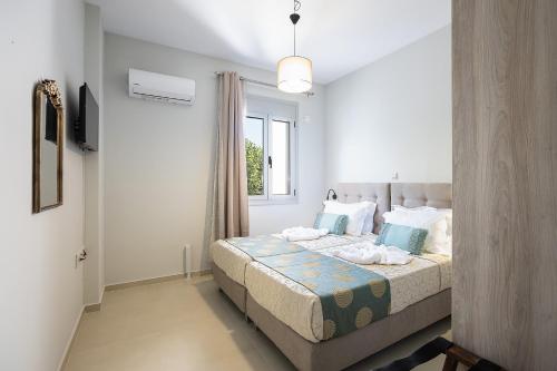a bedroom with a bed with blue pillows and a window at Sophias View in Loutra
