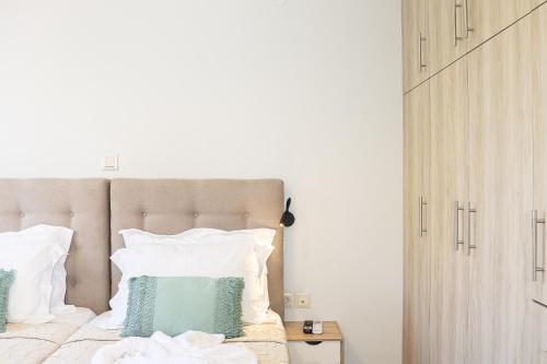 a bedroom with a bed with green and white pillows at Sophias View in Loutra