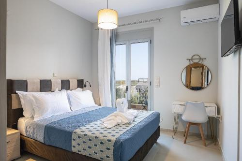 a bedroom with a bed with a blue comforter and a window at Sophias View in Loutra