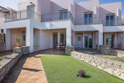 a large white house with a lawn in front of it at Sophias View in Loutra