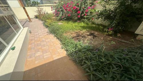 une allée en briques devant une maison avec des fleurs dans l'établissement Albarsha Villa Fully Furnished Luxury Private Master Room Ensuite Huge Space Deluxe, à Sabkhah