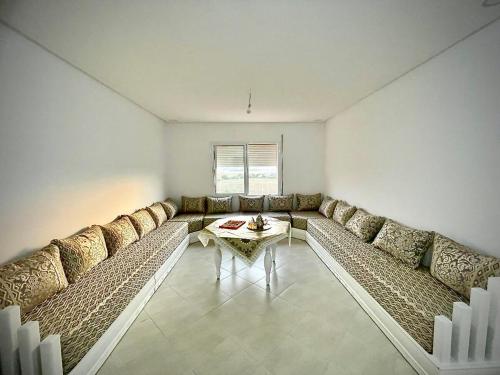 a living room with a couch and a table at Appartement 2 chambres en ville in Saidia 