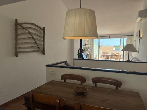 a dining room table with two chairs and a mirror at Riera Rossello 2 in Fornells