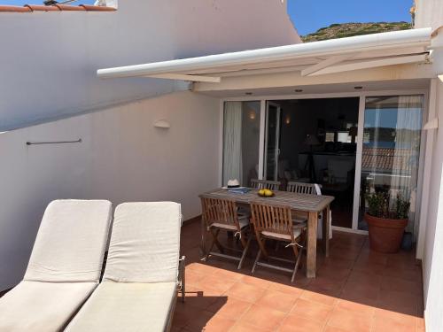 a patio with a table and chairs on a balcony at Riera Rossello 2 in Fornells