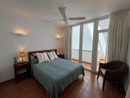 a bedroom with a bed and a ceiling fan at Riera Rossello 2 in Fornells