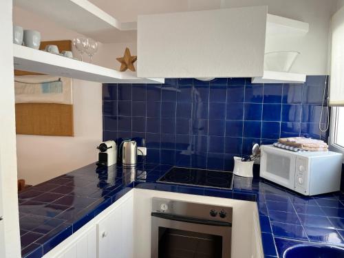 a kitchen with a blue tiled counter top at Riera Rossello 2 in Fornells