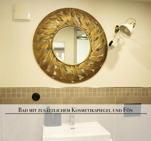 La salle de bains est pourvue d'un miroir mural en or. dans l'établissement Naturferienhaus Mittlere Elbe, à Groß Rosenburg