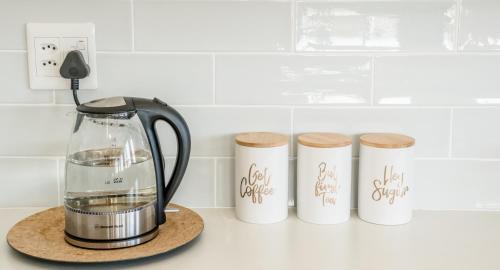 a kitchen counter with a blender and four test tubes at Escape to Pringle in Pringle Bay