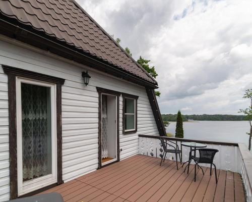 a house with a deck with a table and chairs at Slėnis Trakuose in Trakai