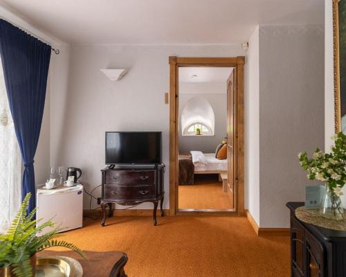 a living room with a television and a bedroom at Slėnis Trakuose in Trakai