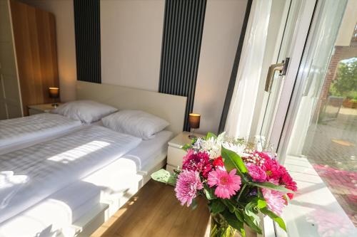a bedroom with a bed and a vase of flowers at Hotel am Park in Braunschweig