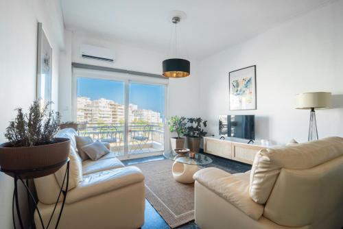 ピレウスにあるMZ Mare Piraeusのリビングルーム(ソファ2台付)、バルコニーが備わります。