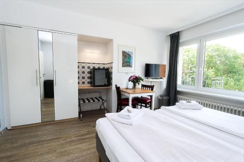 a hotel room with two beds and a desk at Hotel am Park in Braunschweig