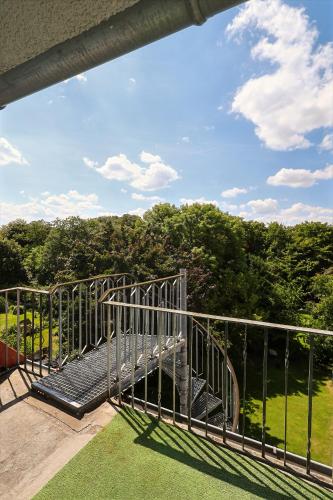 a balcony with a metal railing with trees in the background at Hotel am Park in Braunschweig