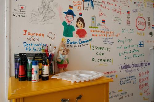 a desk with a wall with writing on it at La Casa Verde Albergue - Solo Peregrinos in San Martín del Camino