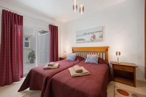 a bedroom with a red bed with towels on it at Apartamento Familiar Old Town in Lagos