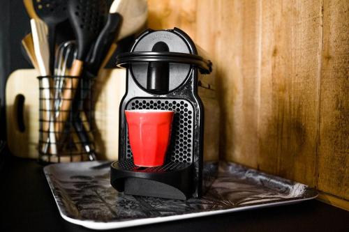 a black coffee maker with a red cup in it at Love Nest - Bergerac Center in Bergerac