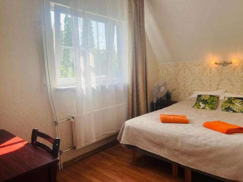 a bedroom with a bed with orange pillows and a window at I&A Residence Humala in Tallinn