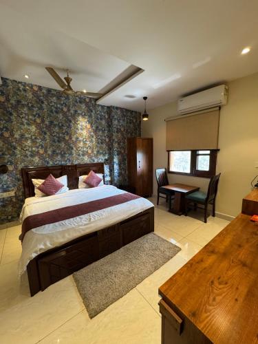 a bedroom with a large bed and a table in it at Sky Star Hotel in Amritsar