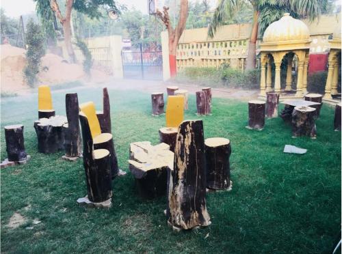 a group of logs sitting on the grass in a park at Hotel Mayur in Alwar