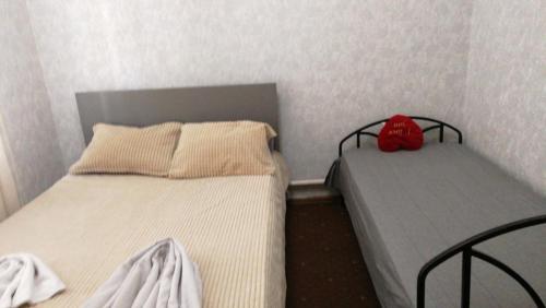 two beds in a small bedroom with a red backpack at Mary&George in Chişinău