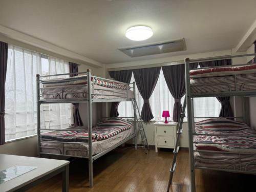 a room with two bunk beds and a table at TOKYOtomo in Wada