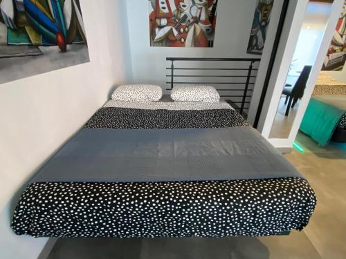 a bed with polka dots on it in a room at Magnifique appartement près du centre in Barcelona